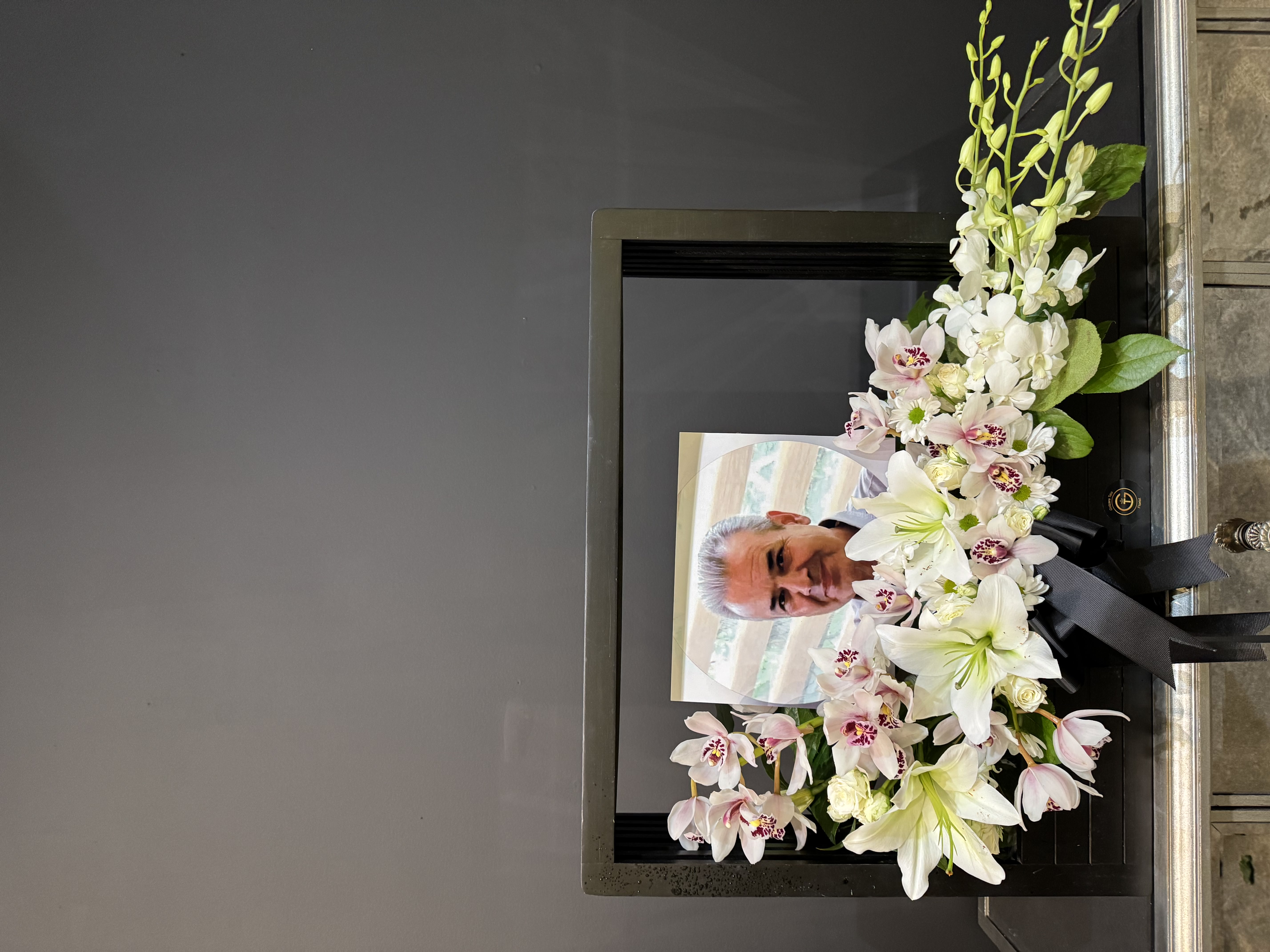 White lily and carnation standing spray with mixed greenery