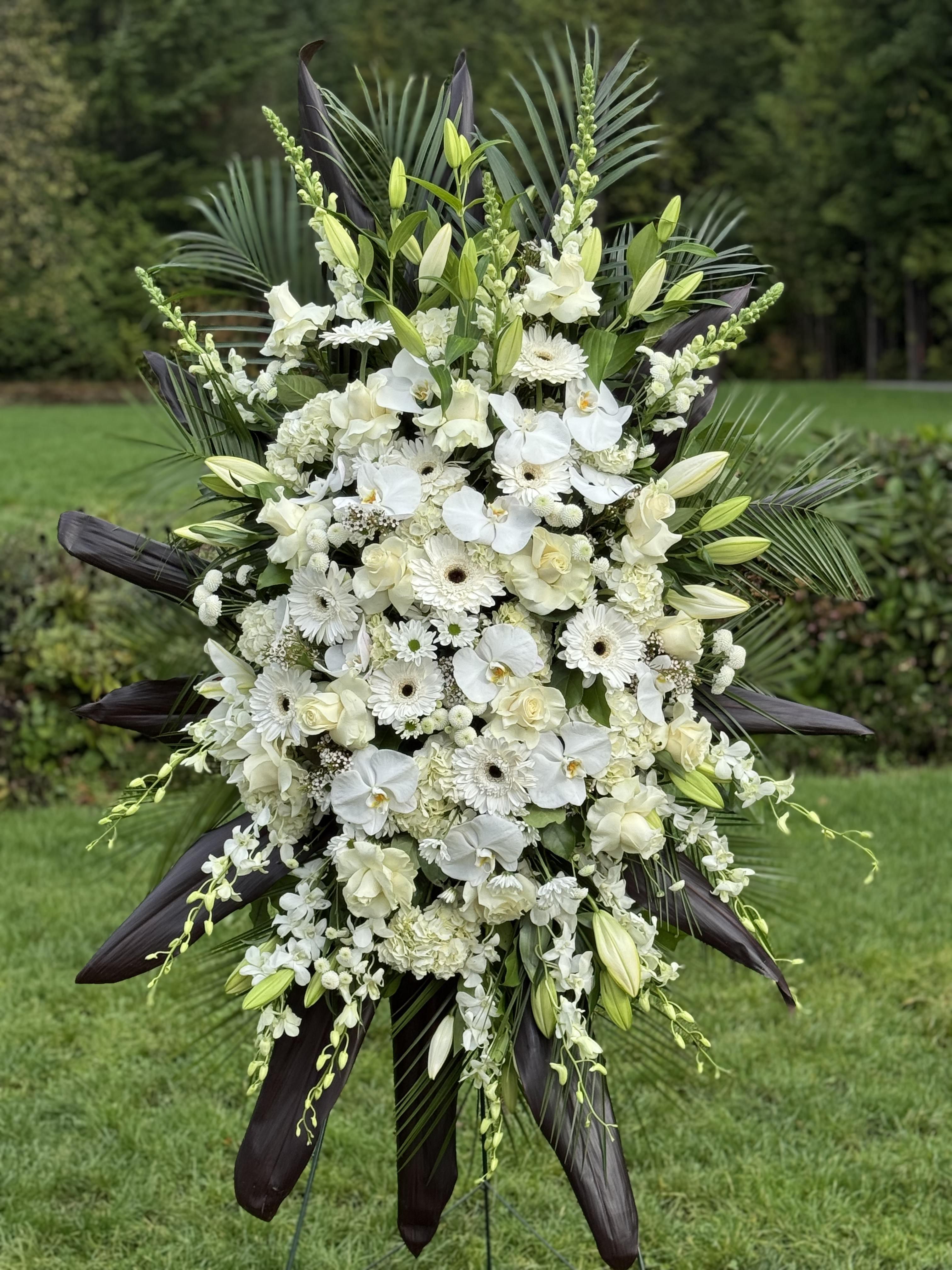 White lily and snapdragon easel spray with flowing greenery