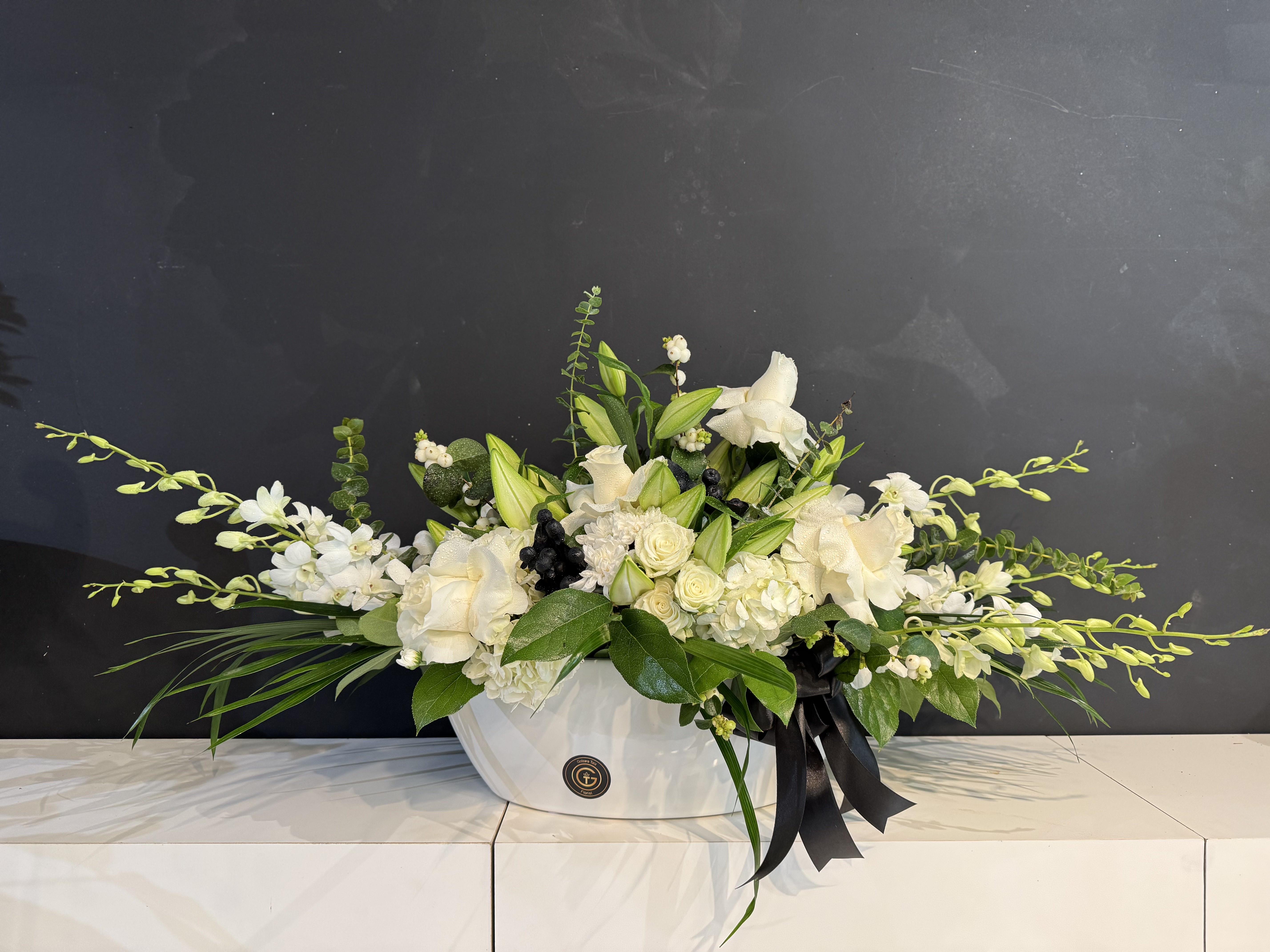 White rose and lisianthus round sympathy wreath with ribbon