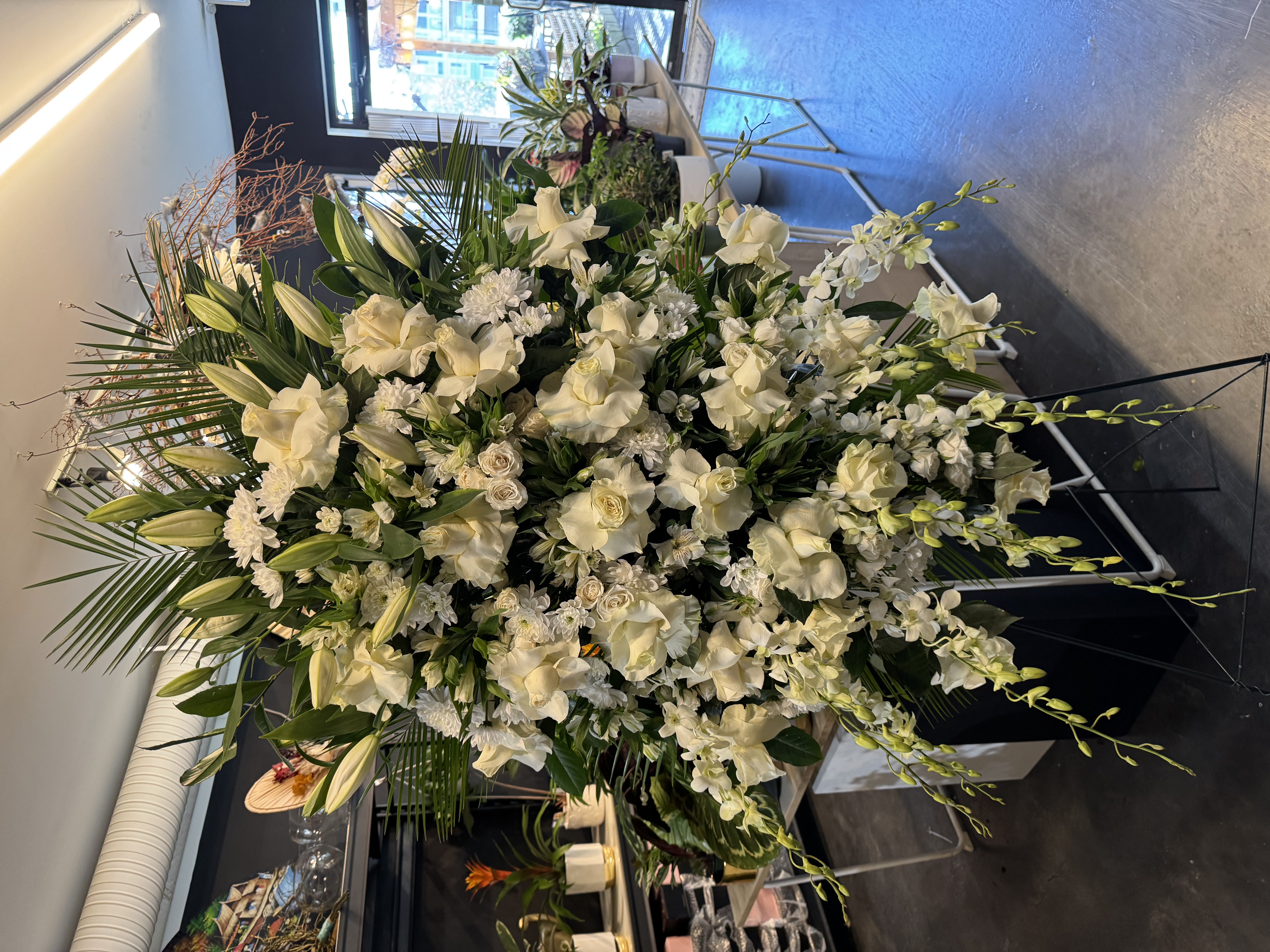 Elegant all-white orchid and rose bridal arrangement with satin wrap