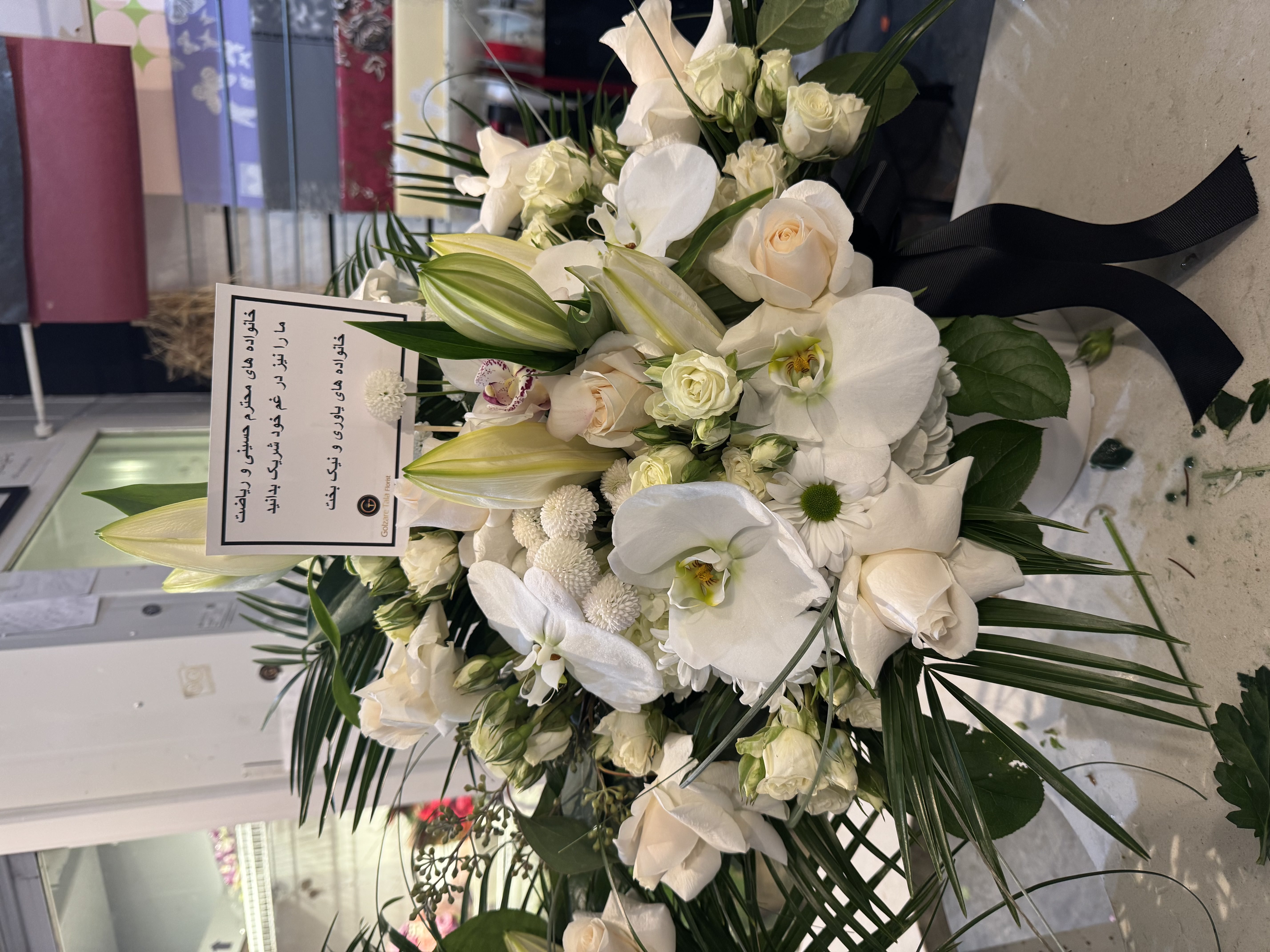 White rose and lisianthus half-casket spray with fern detail