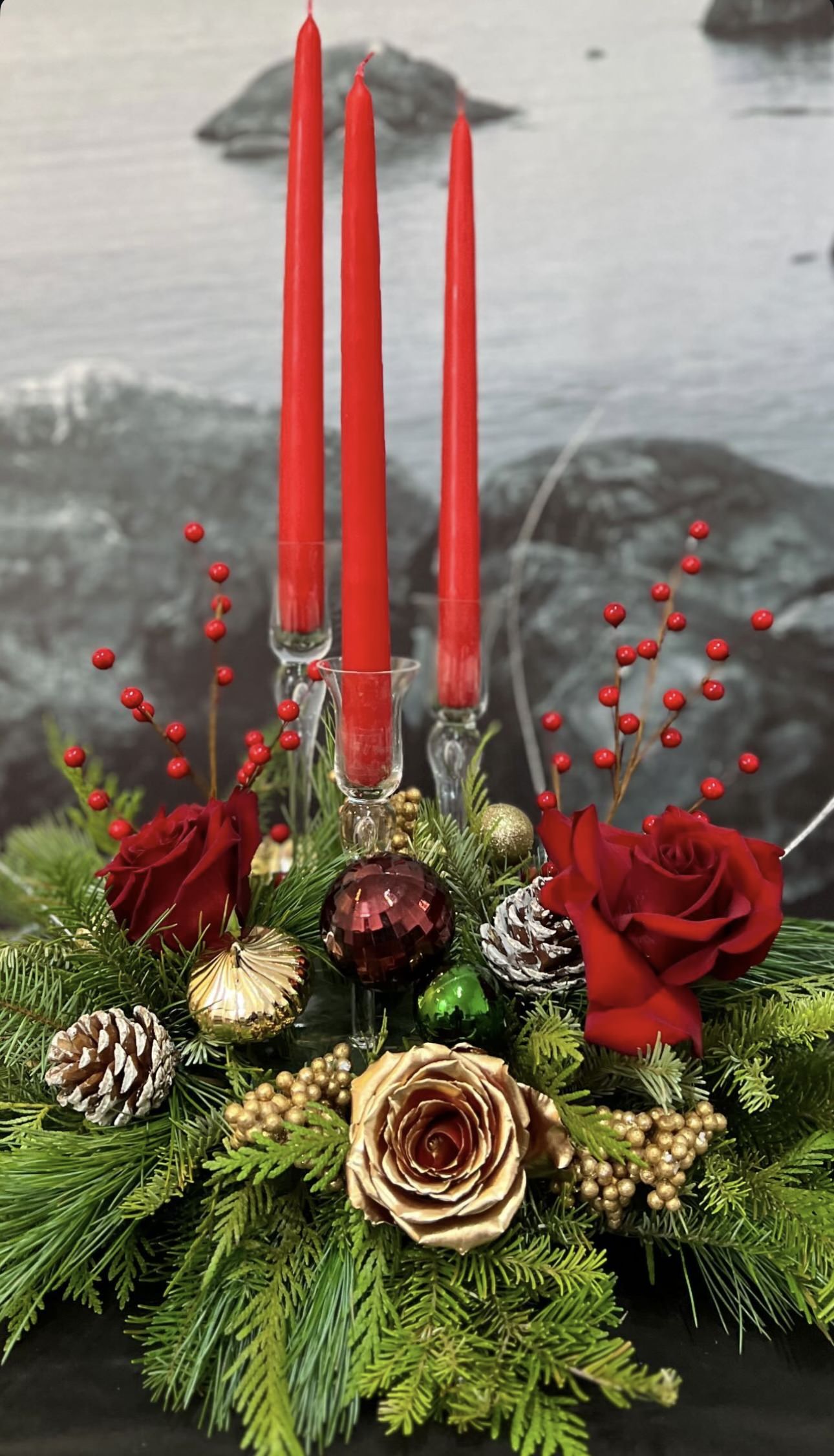 Romantic holiday arrangement with deep reds and lush greenery for a kiss under the mistletoe
