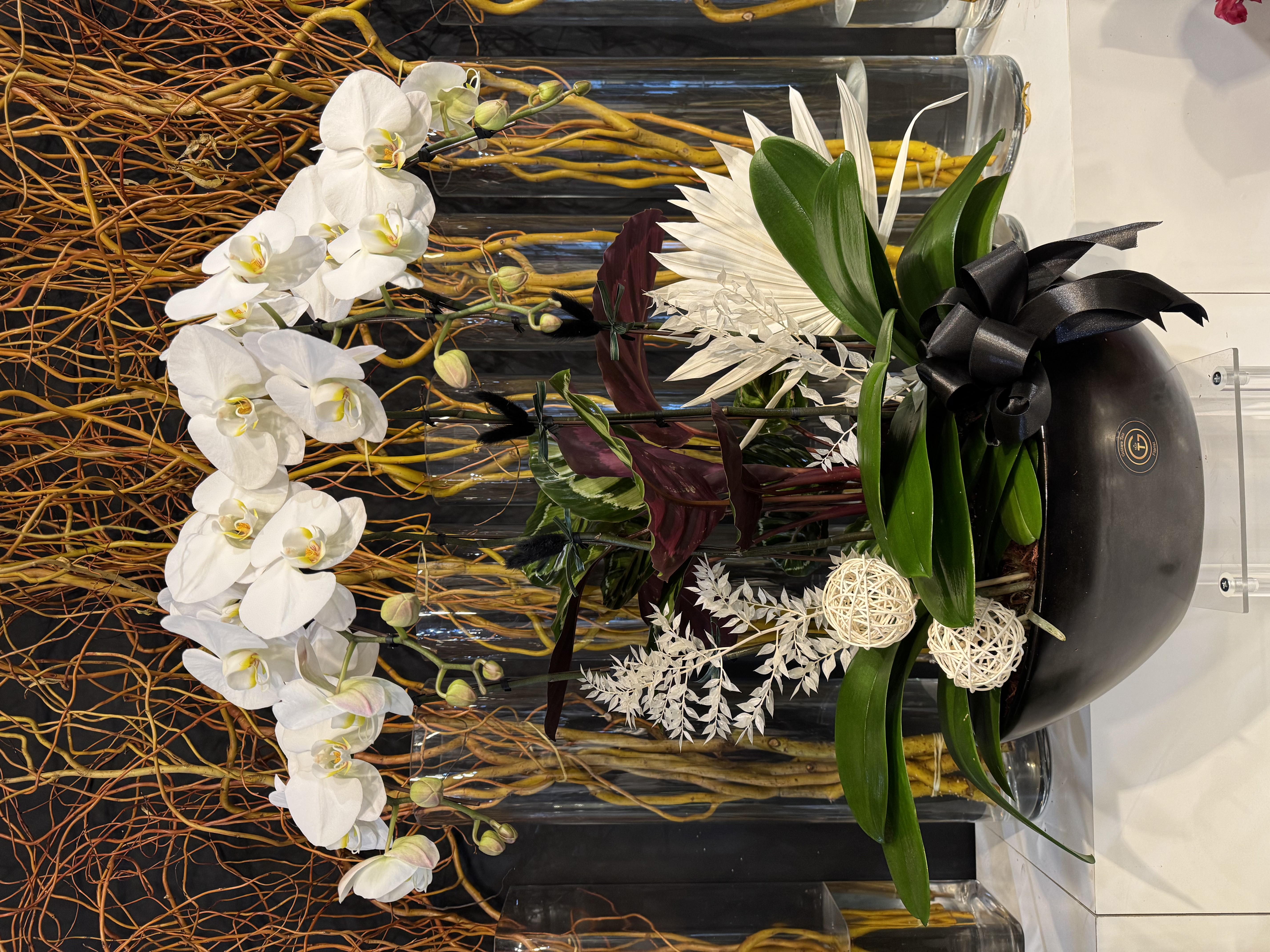 White rose and orchid round wreath with elegant ribbon drape