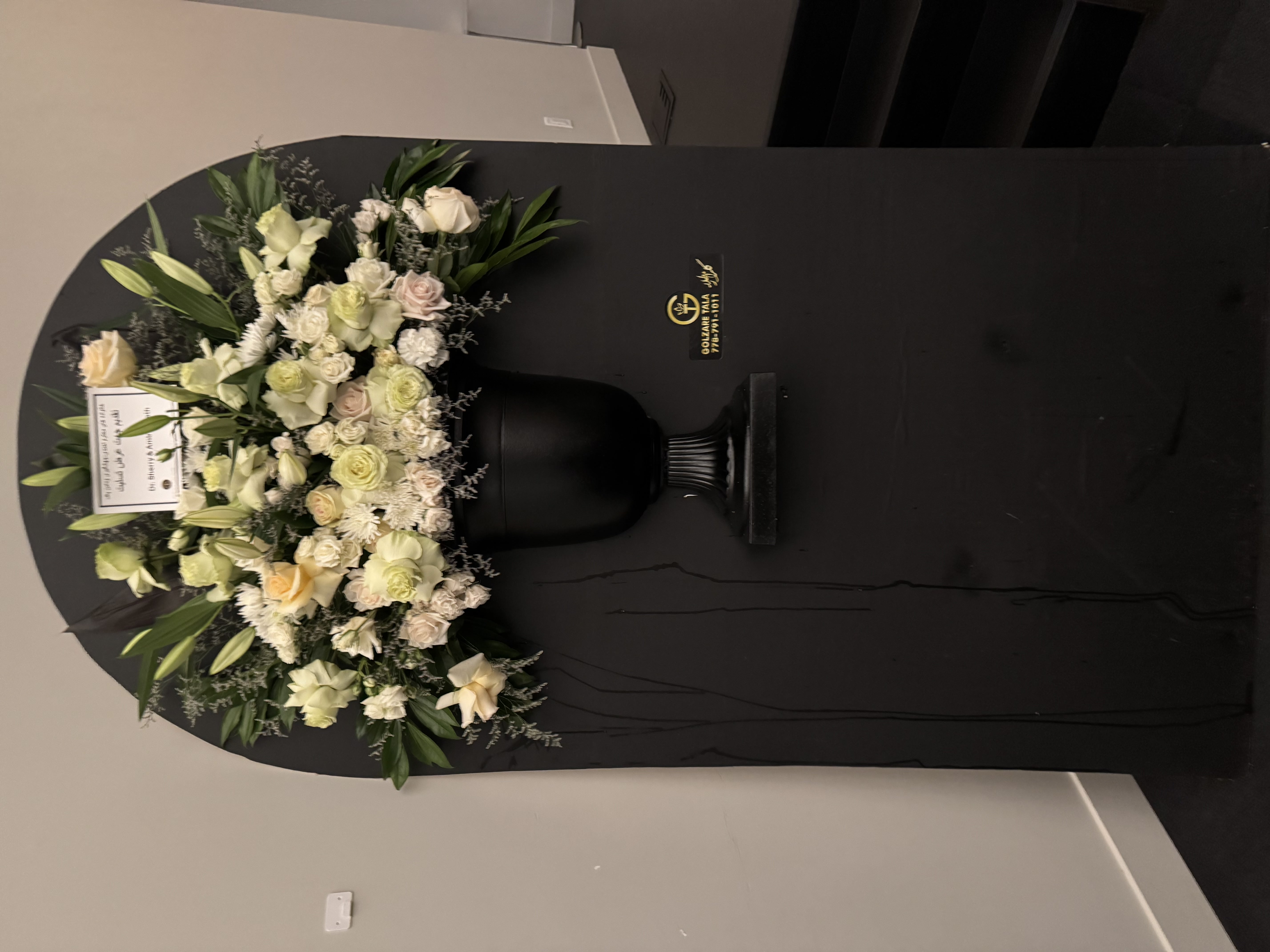 White lily and rose sympathy arrangement with elegant greenery
