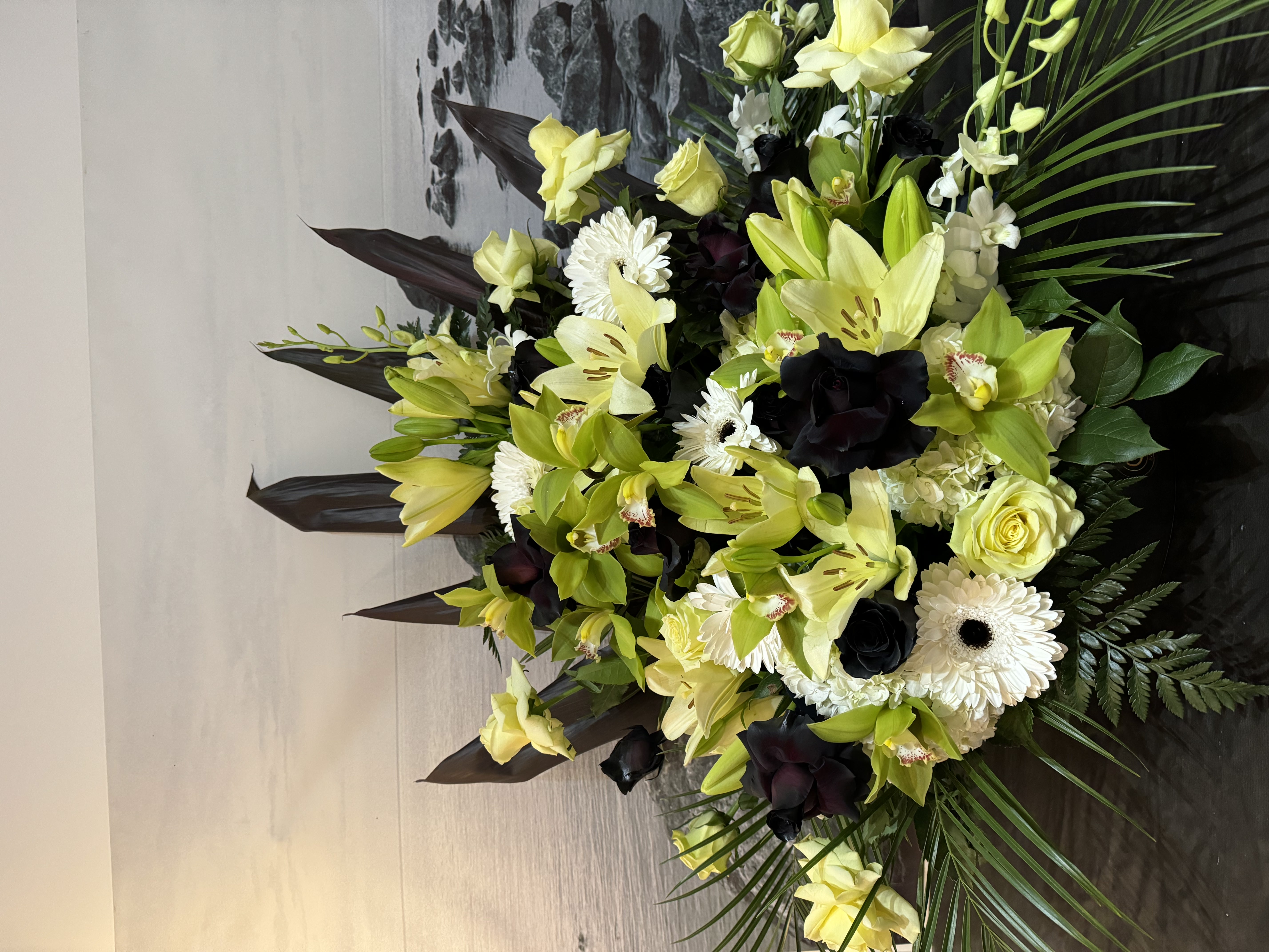 Cream rose and white carnation standing spray with palm leaves