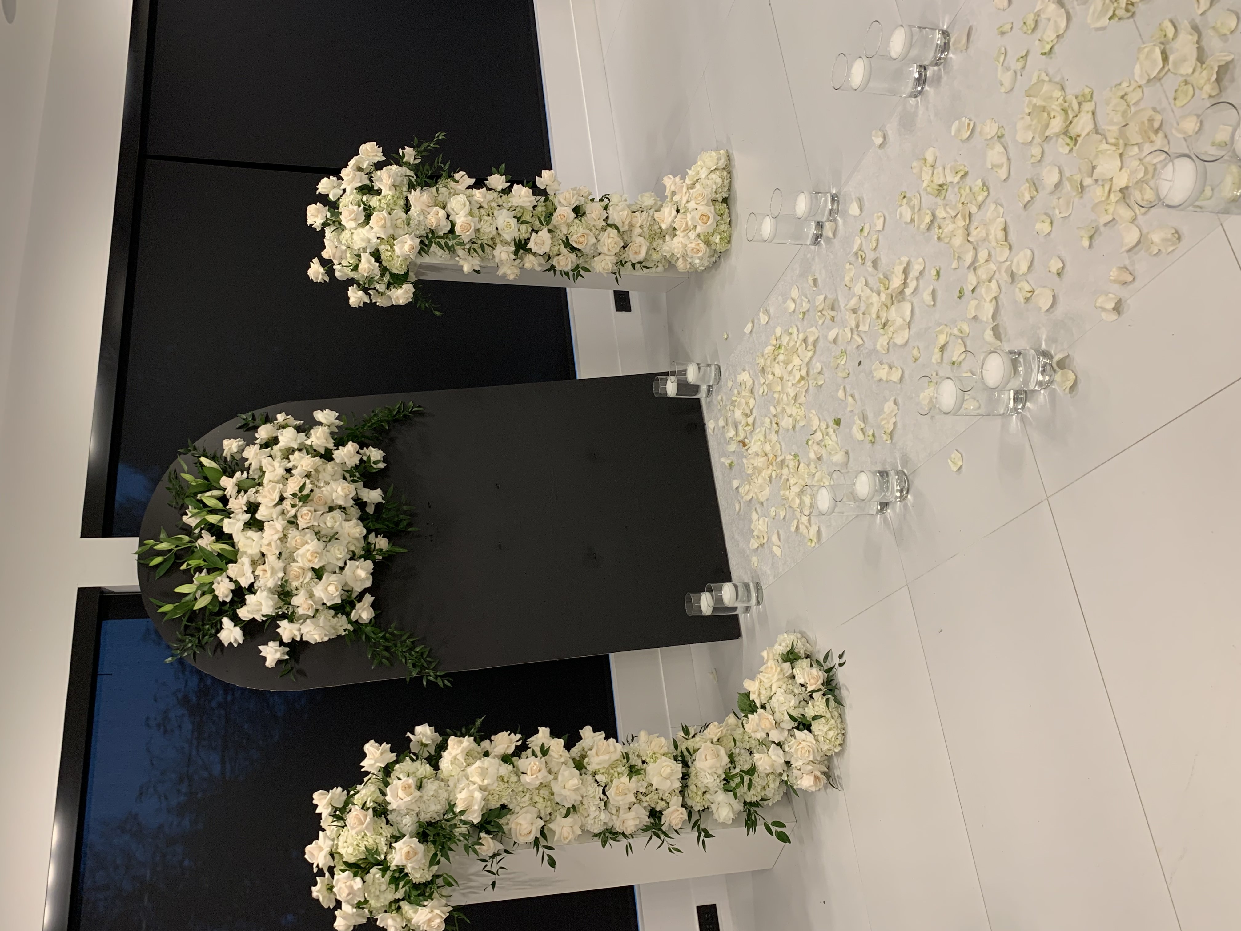 All-white orchid and rose casket spray with flowing ribbon