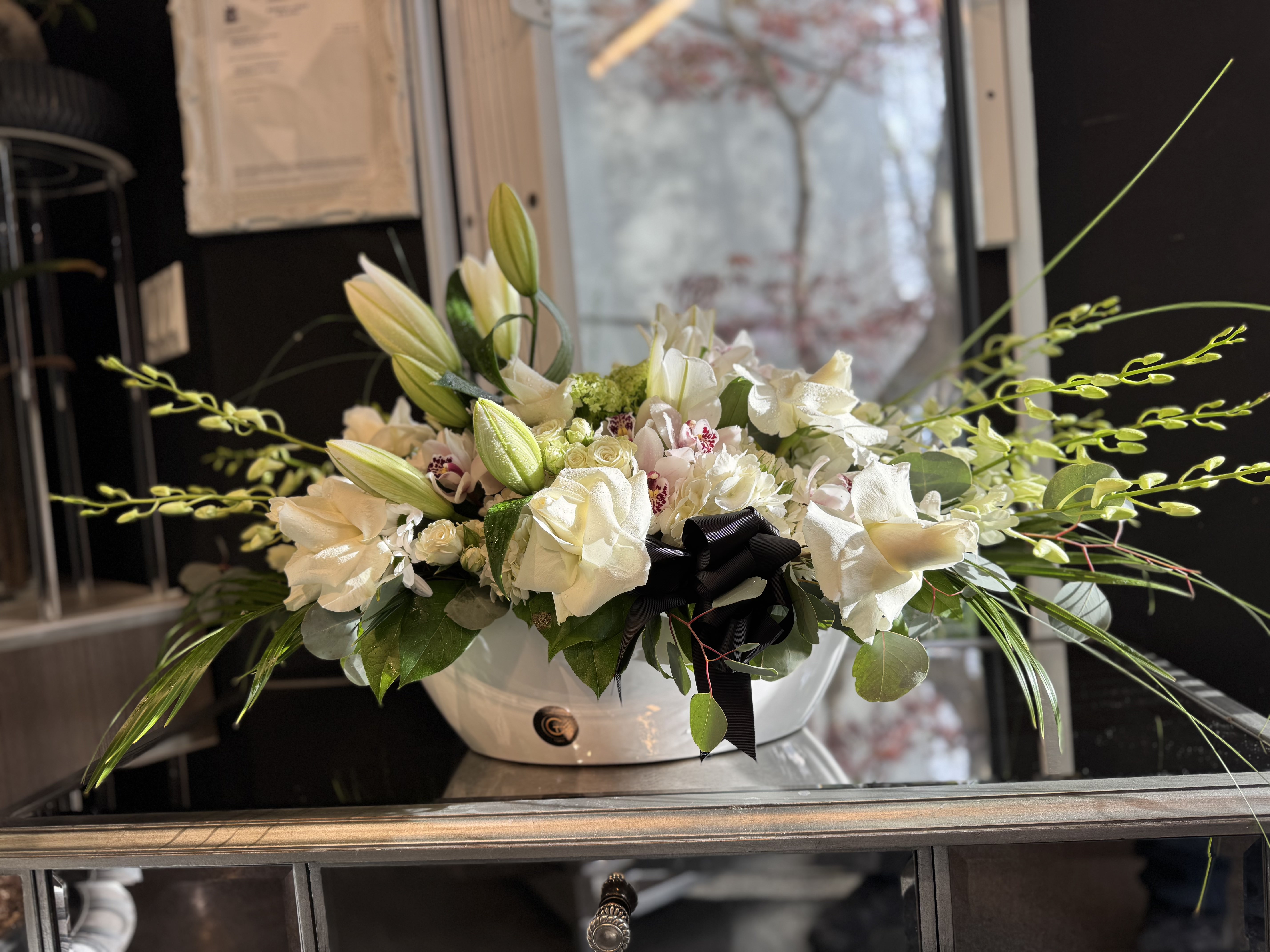 White orchid and rose sympathy arrangement in elegant ceramic vase