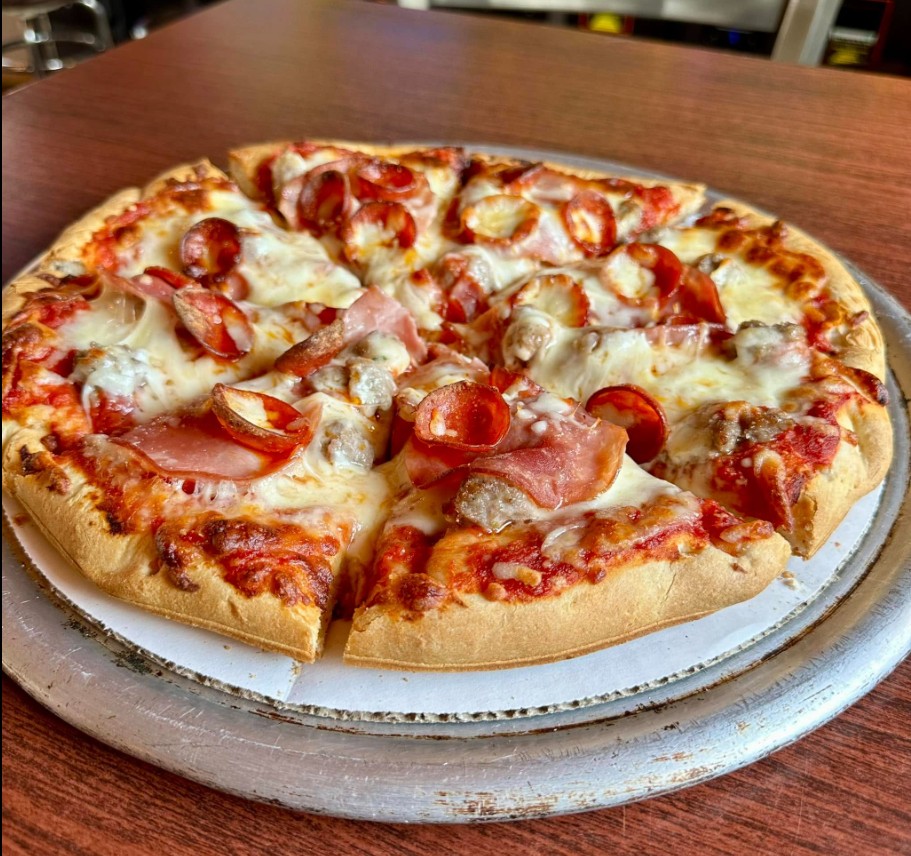 Handcrafted meat lovers pizza piled high with sausage, pepperoni, and bacon — made fresh at Tipsy Tee Tavern in Adams, WI