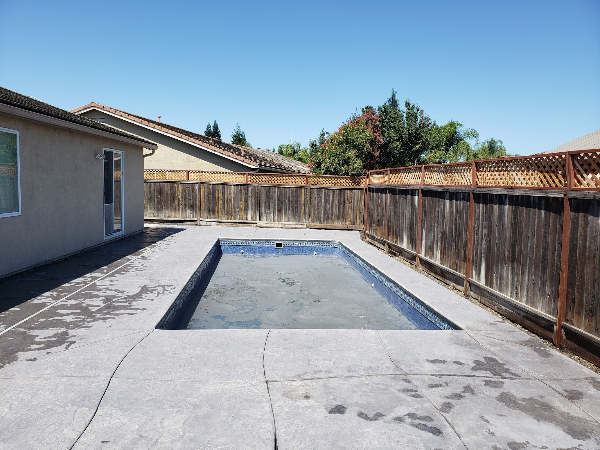 Clean concrete pool deck with rectangular pool in Stockton, CA