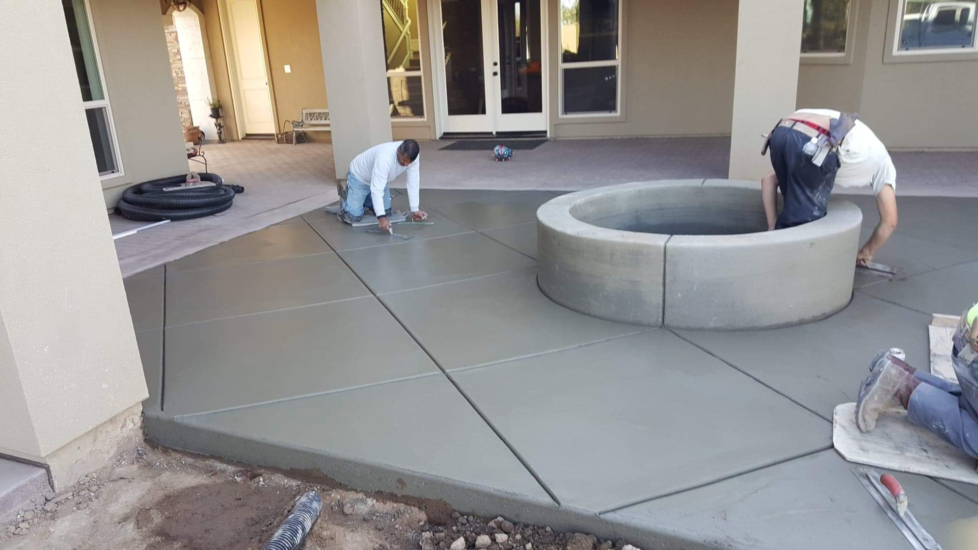 Crew finishing a stamped concrete patio with fire pit in Manteca, CA