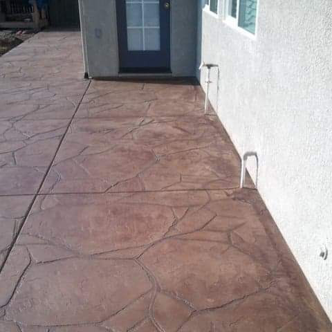 Reddish stamped concrete walkway with stone pattern in Tracy, CA