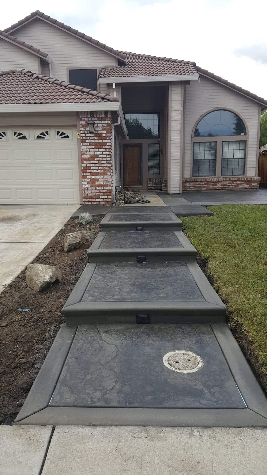 Dark stained concrete steps with decorative border in front of a home in Manteca, CA