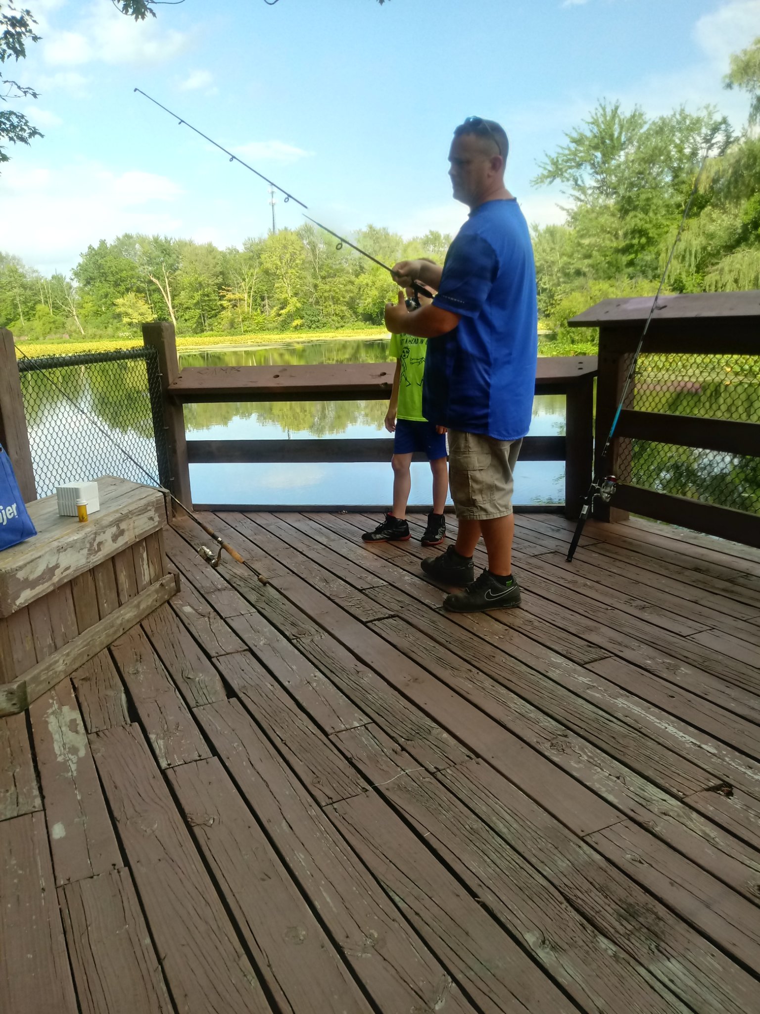 Father and son fishing together on a dock