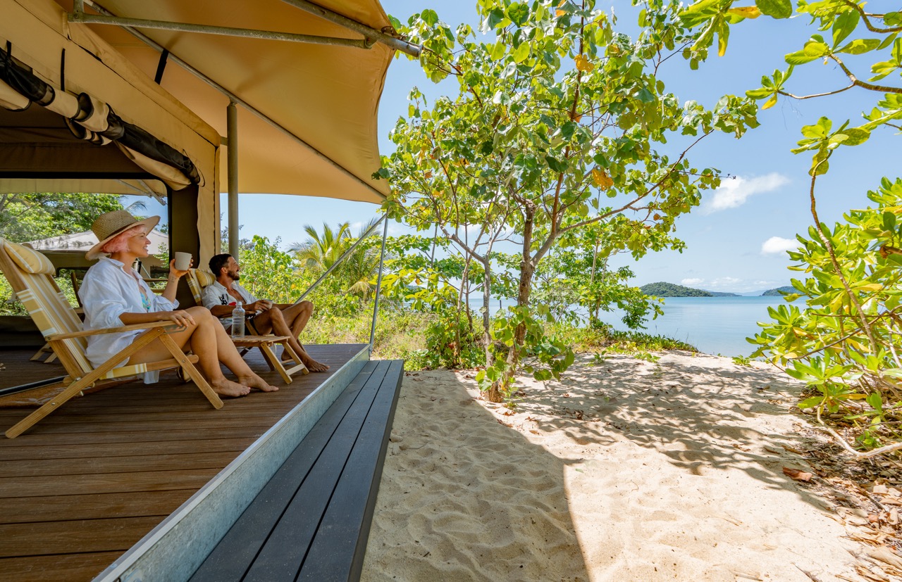 Couple enjoying the view from a beachfront eco tent