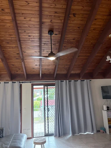 Ceiling fan with exposed wooden beams