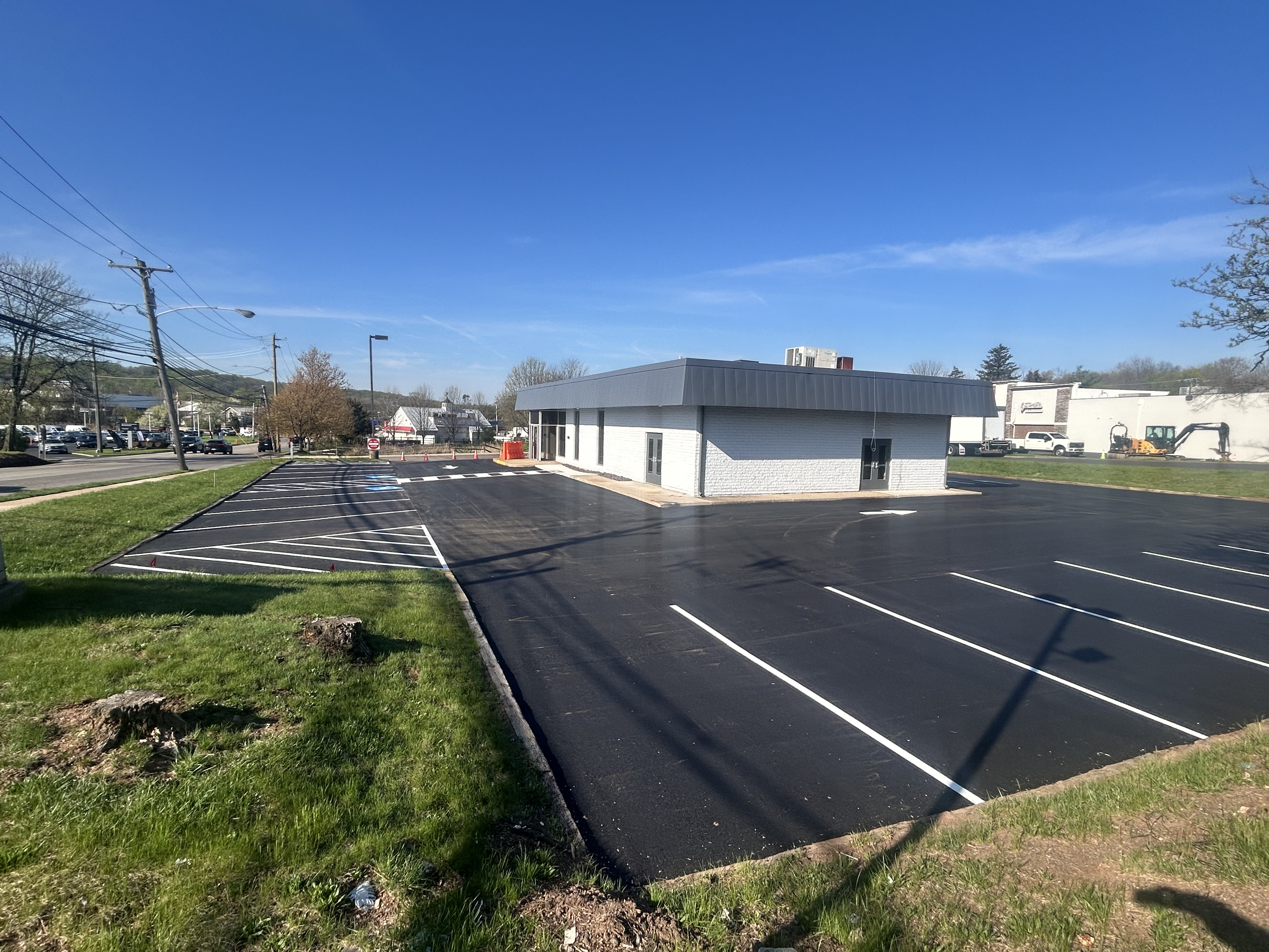 Residential driveway replacement with fresh asphalt and garage apron