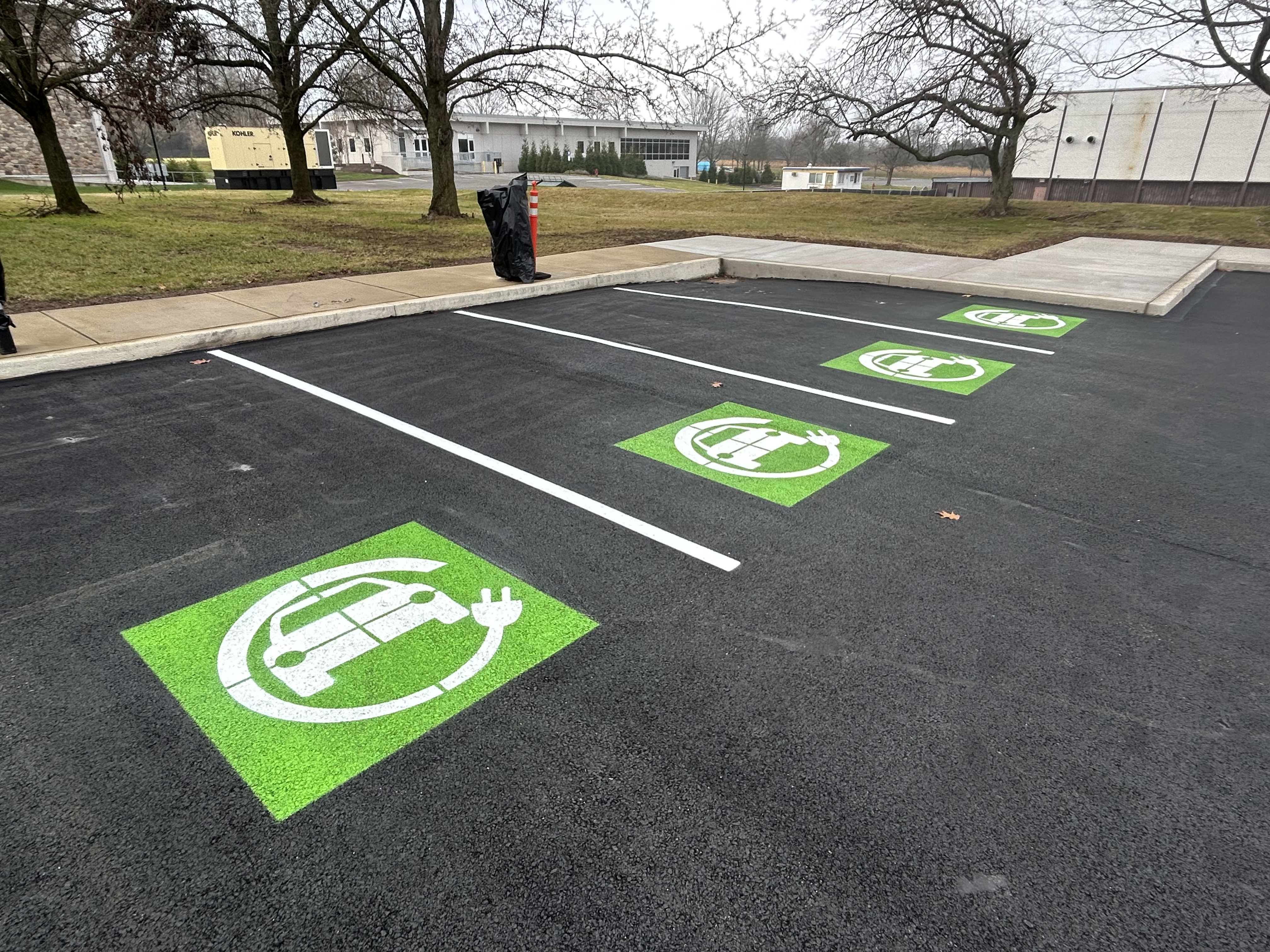 Professional parking lot line striping with crisp white markings on fresh black asphalt