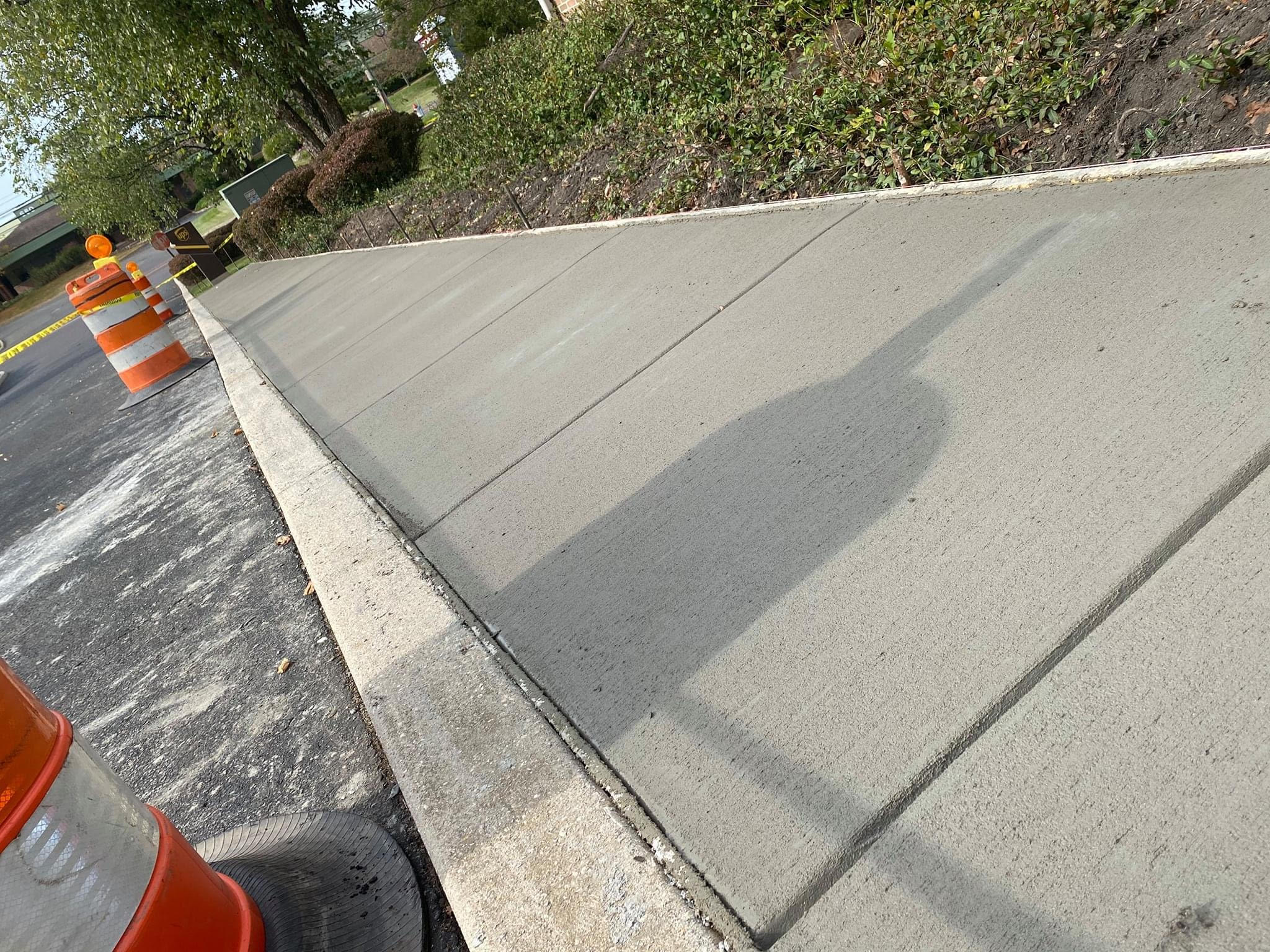 Newly installed concrete sidewalk with broom finish and expansion joints