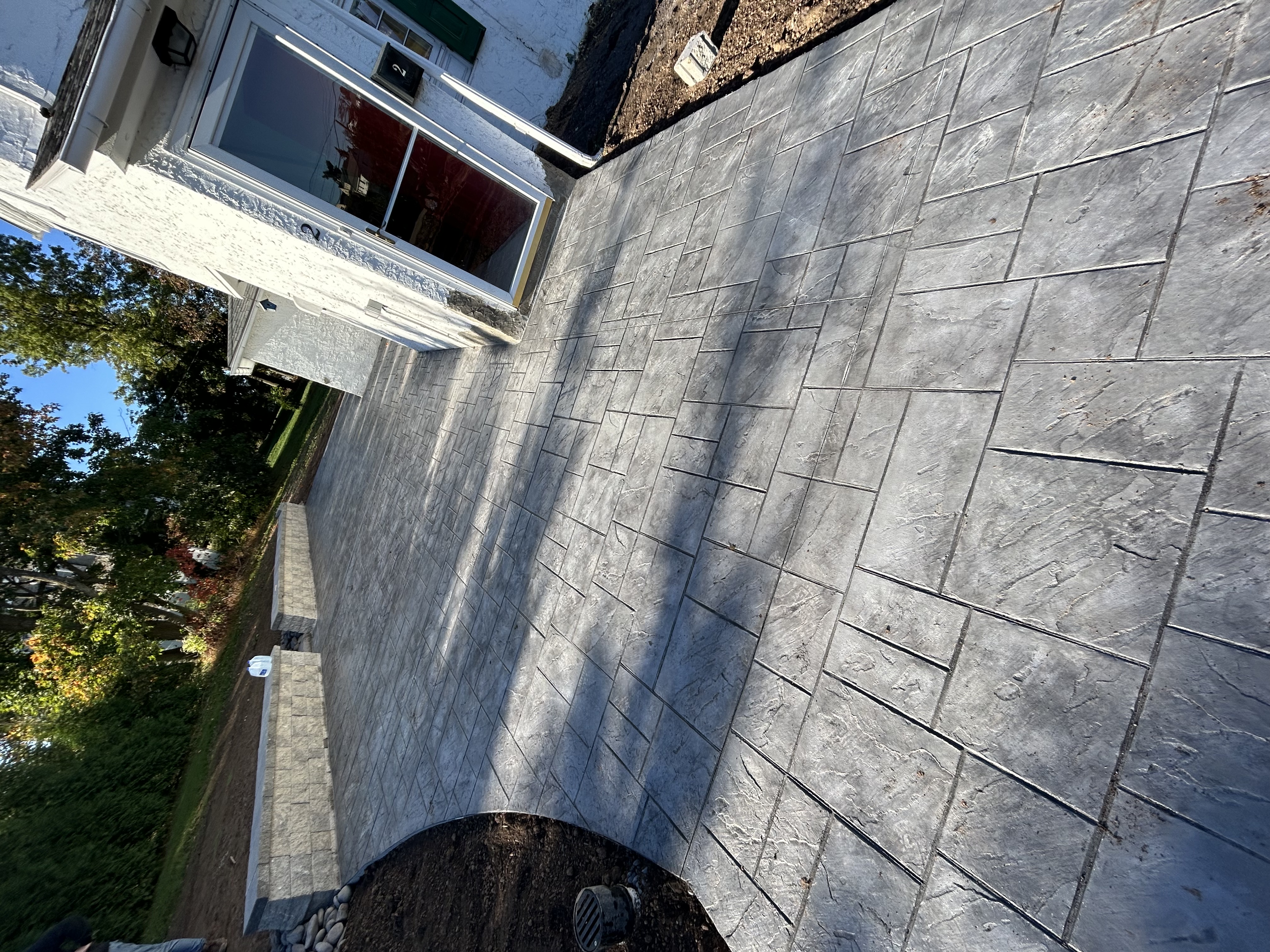 Decorative stamped concrete backyard patio with sandstone coloring