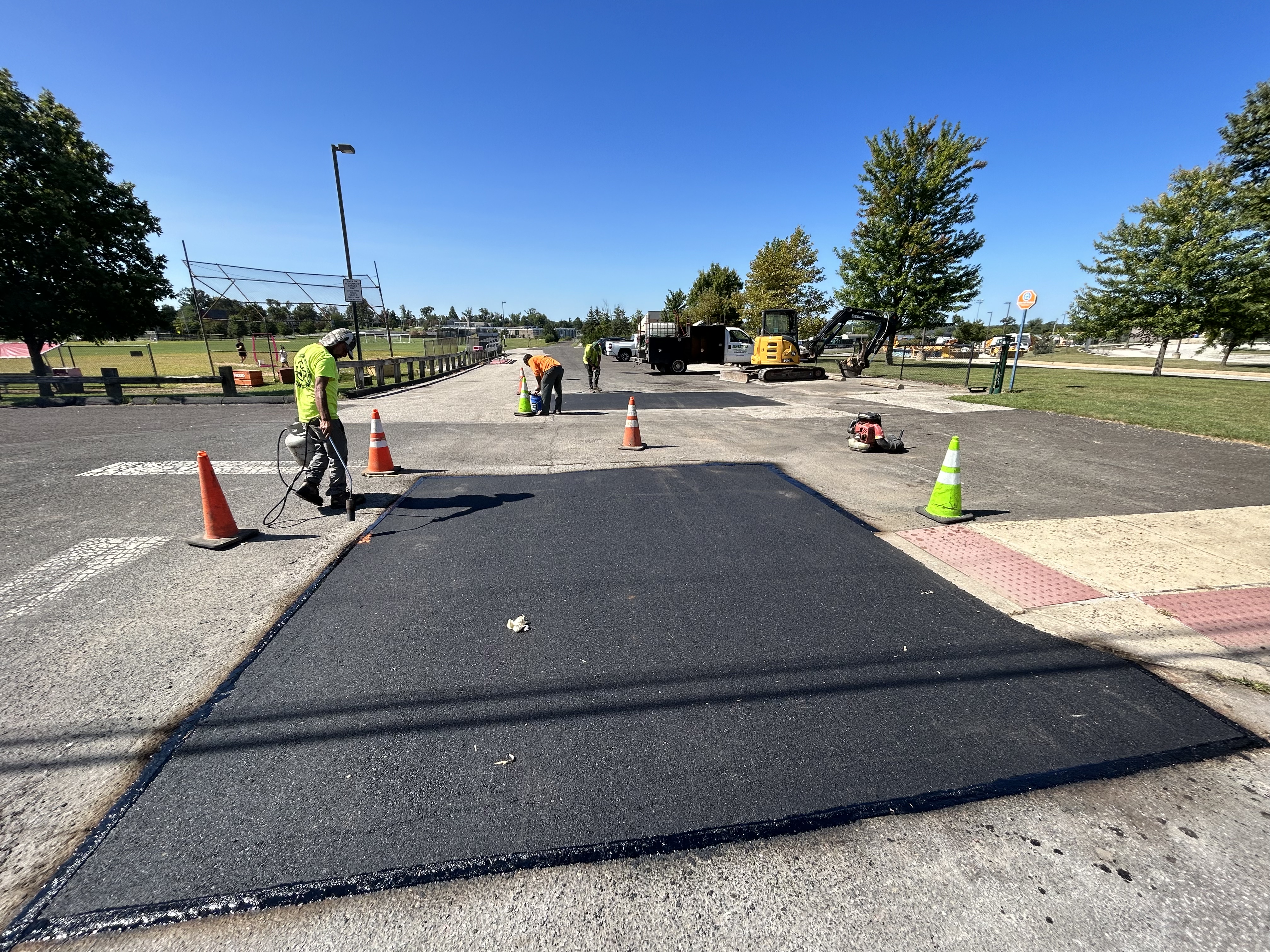 Professional asphalt paving crew resurfacing a municipal roadway during prime paving season in Pennsylvania