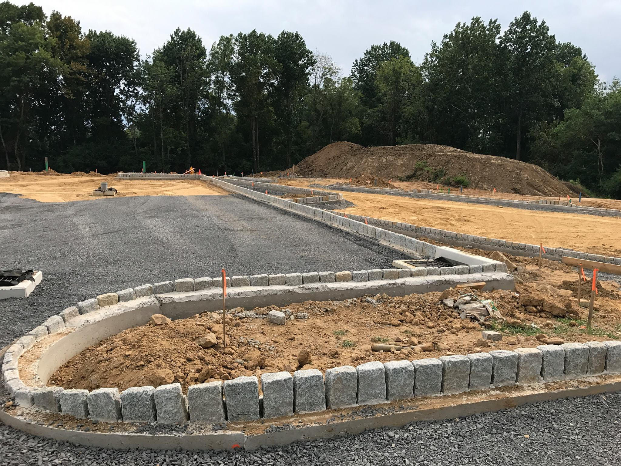 Heavy equipment spreading and compacting base material on site