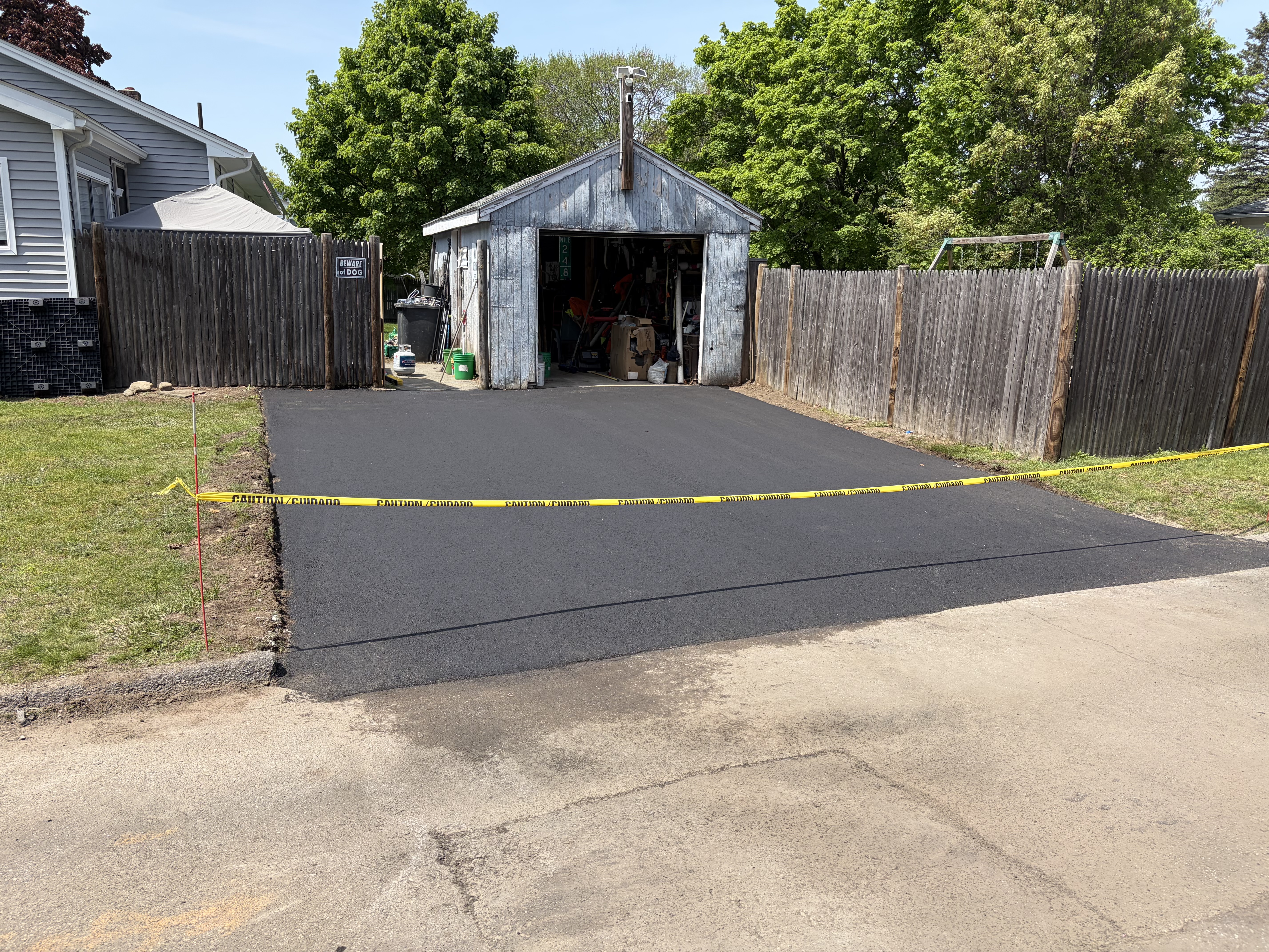 Completed residential asphalt driveway installation in Methuen, MA with smooth black finish