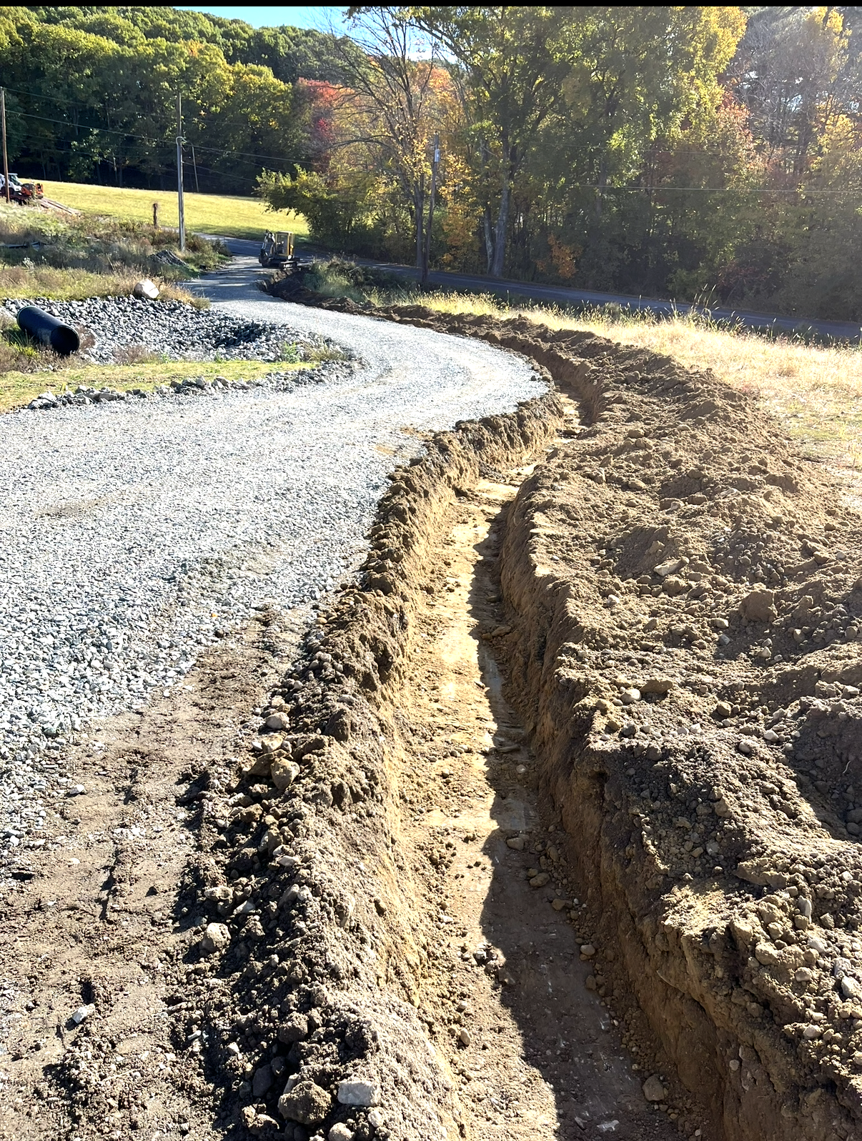 Excavator performing site excavation for a large asphalt paving project.