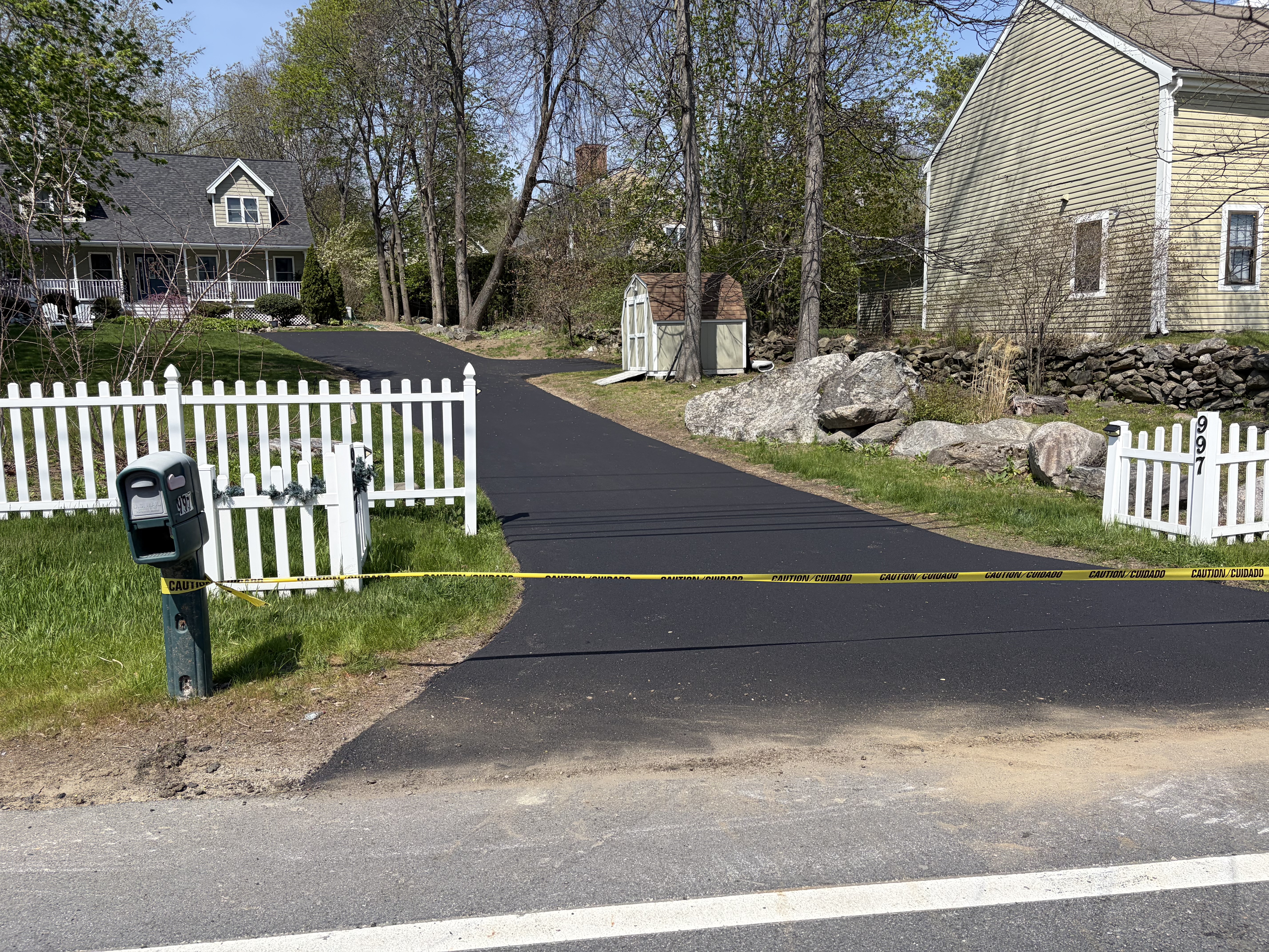 Clean asphalt driveway with garage access after gravel conversion in Georgetown, MA