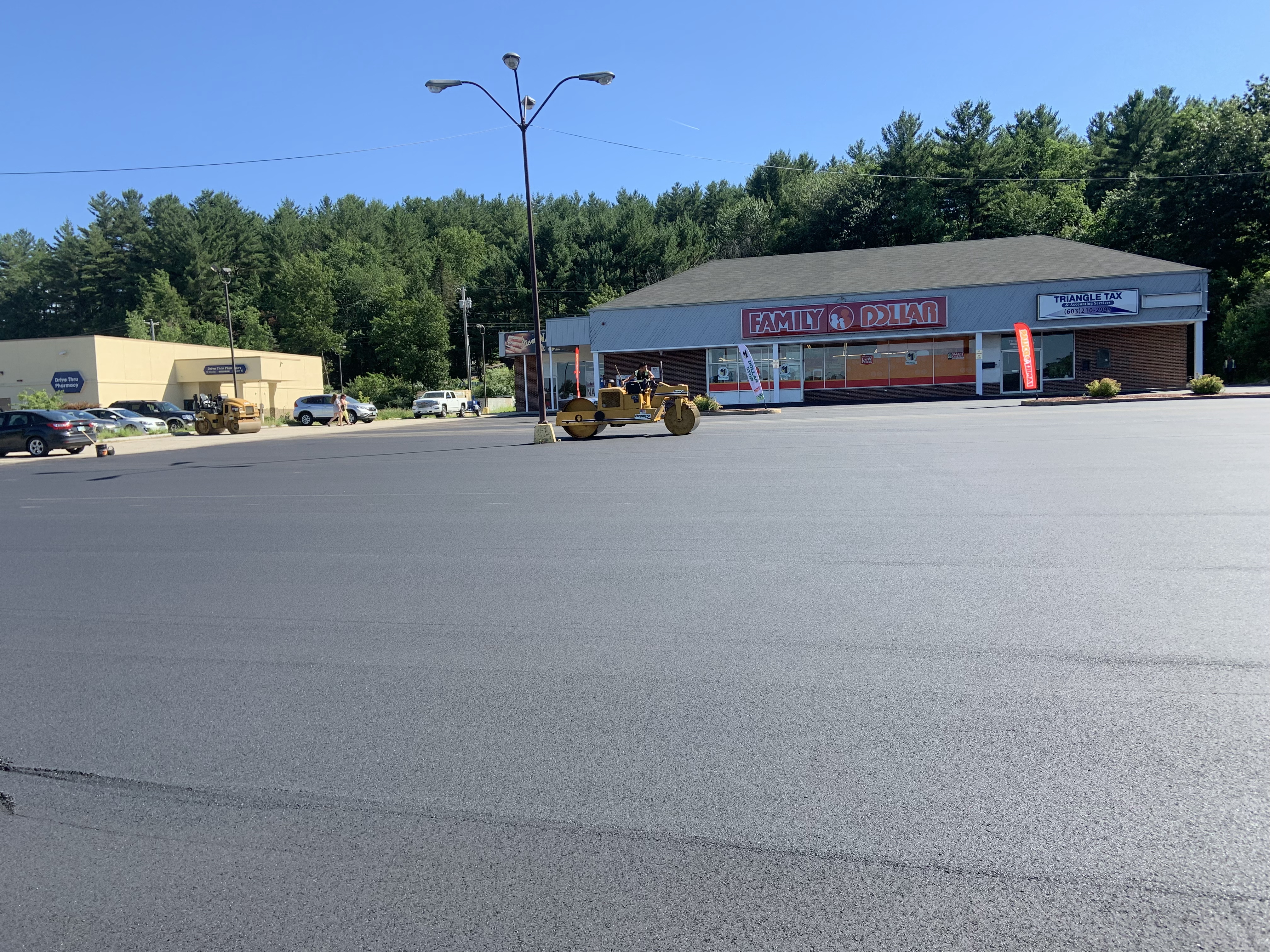 Commercial asphalt paving project in progress at a business property in Massachusetts.