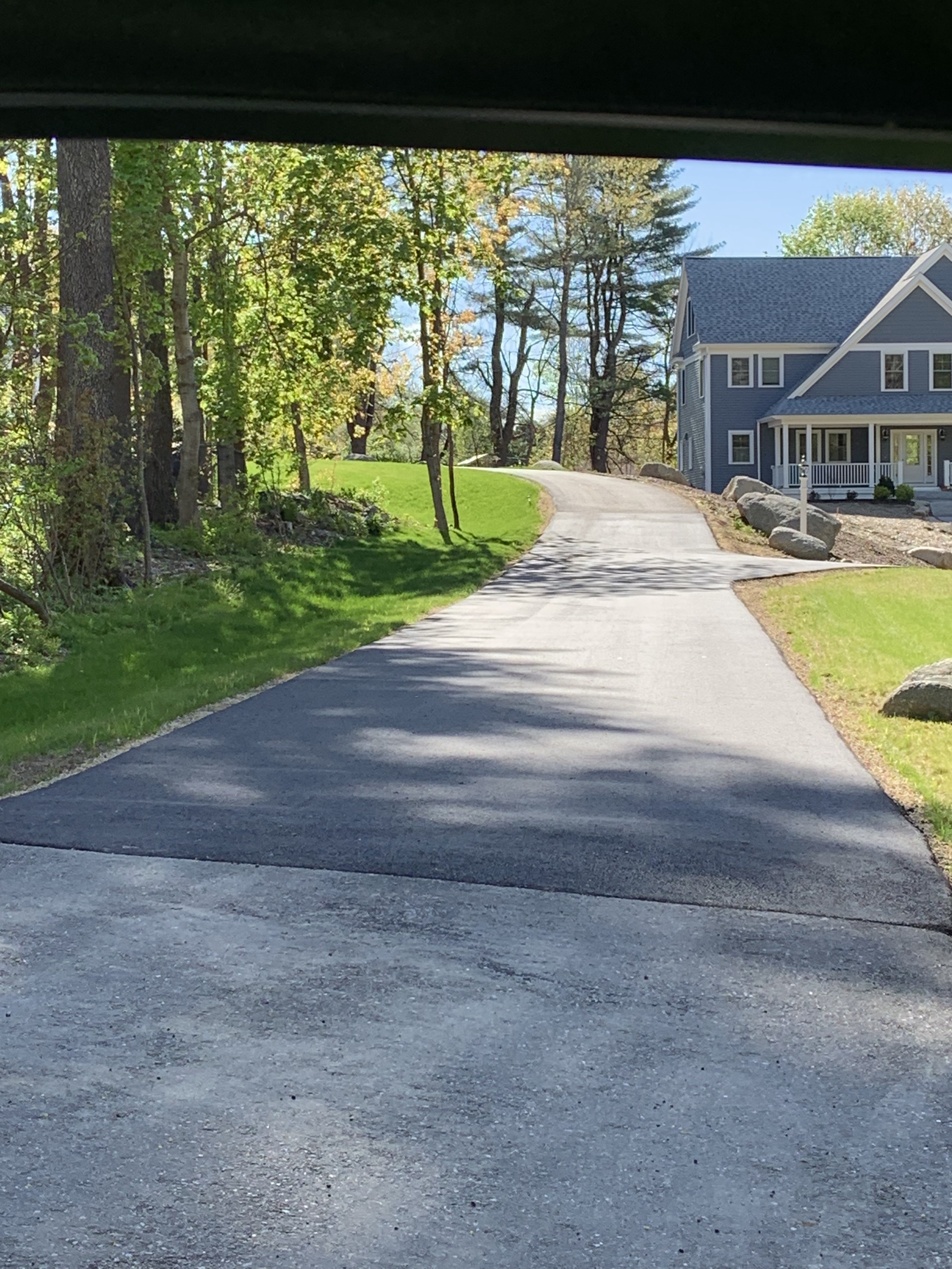 Freshly paved residential asphalt driveway with clean edges in Massachusetts.