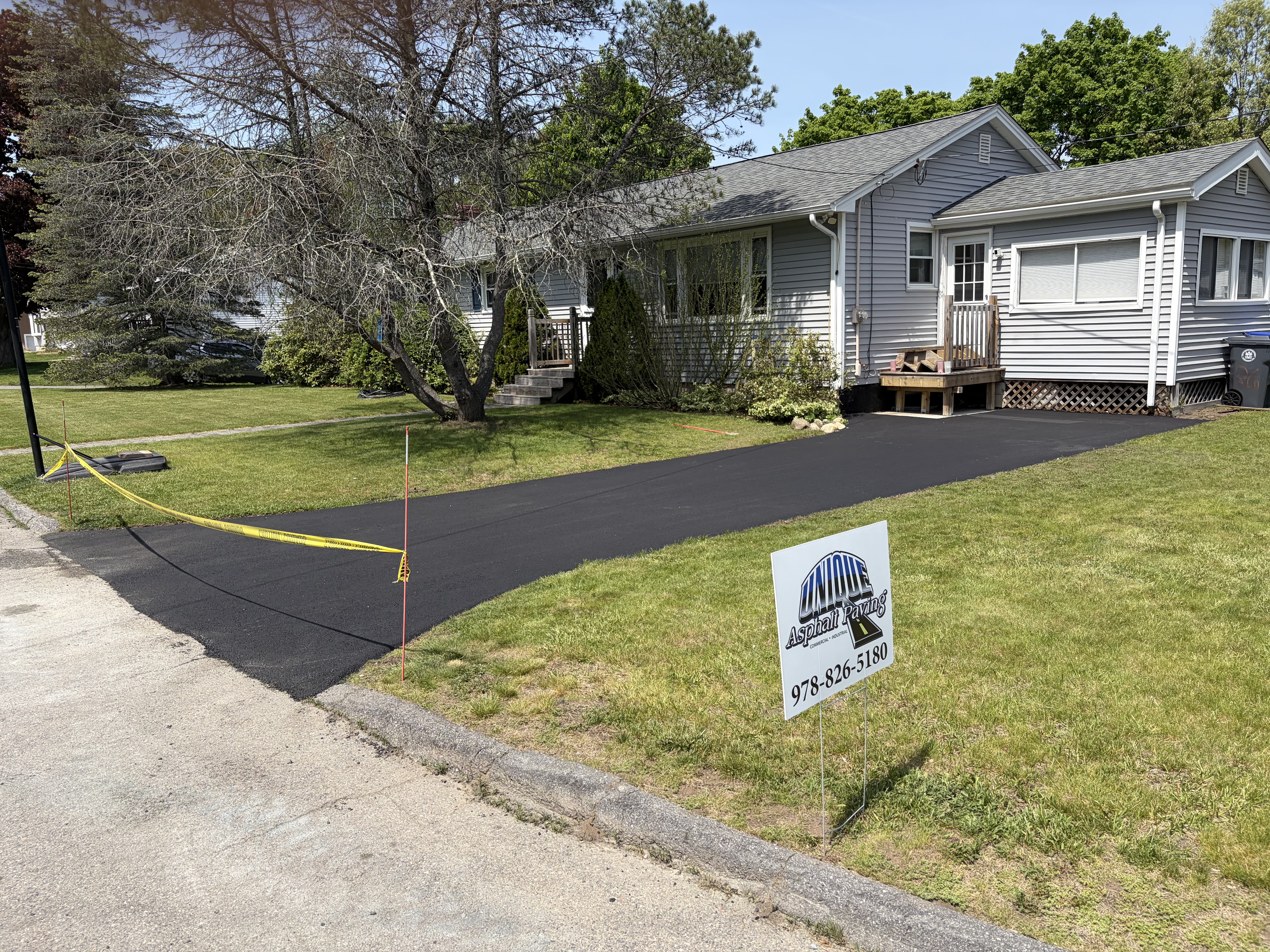 Residential driveway paving project with clean edges and professional asphalt finish in Massachusetts
