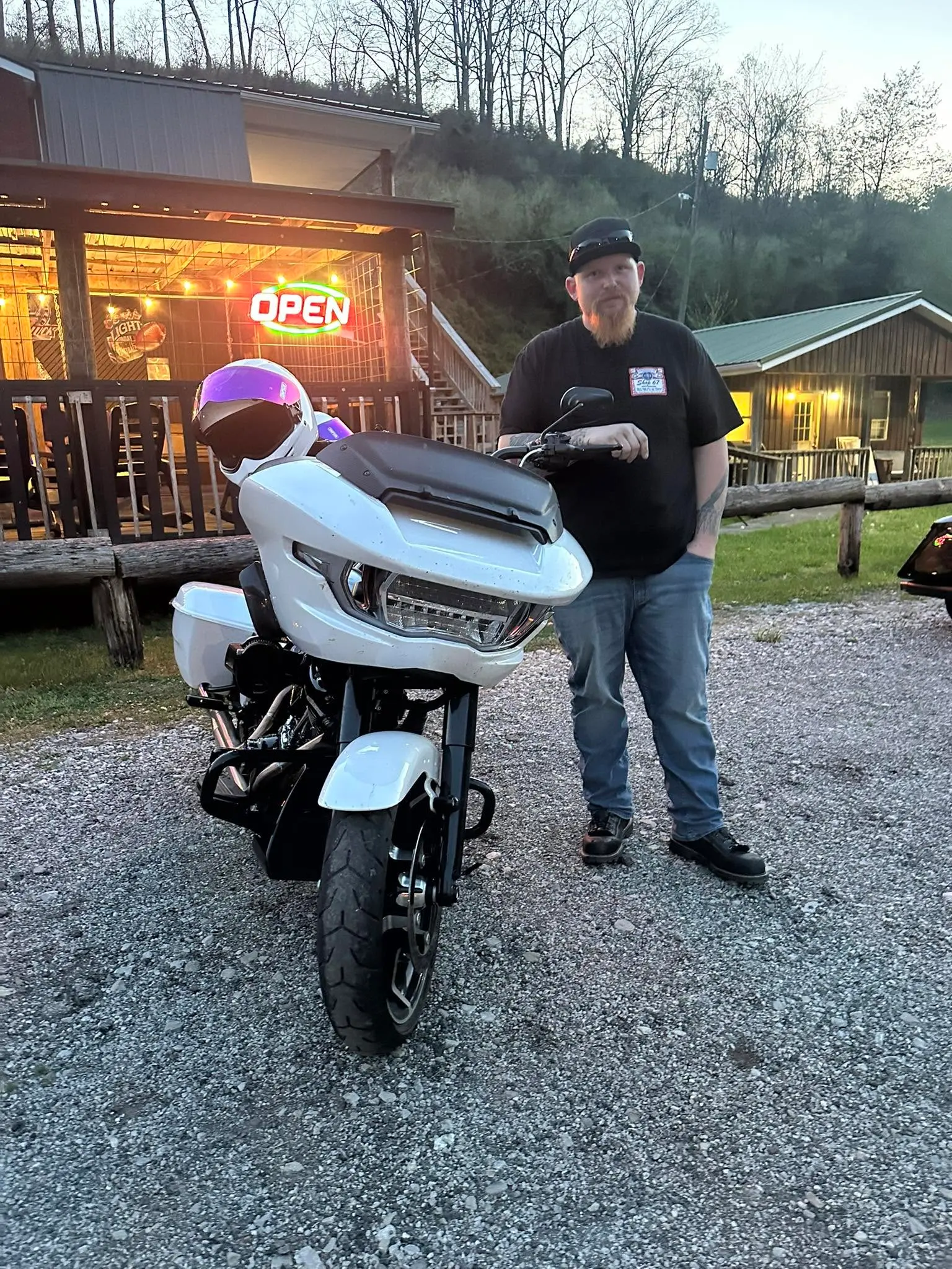 Open neon sign and motorcycle at The Farm Bar & Grill entrance