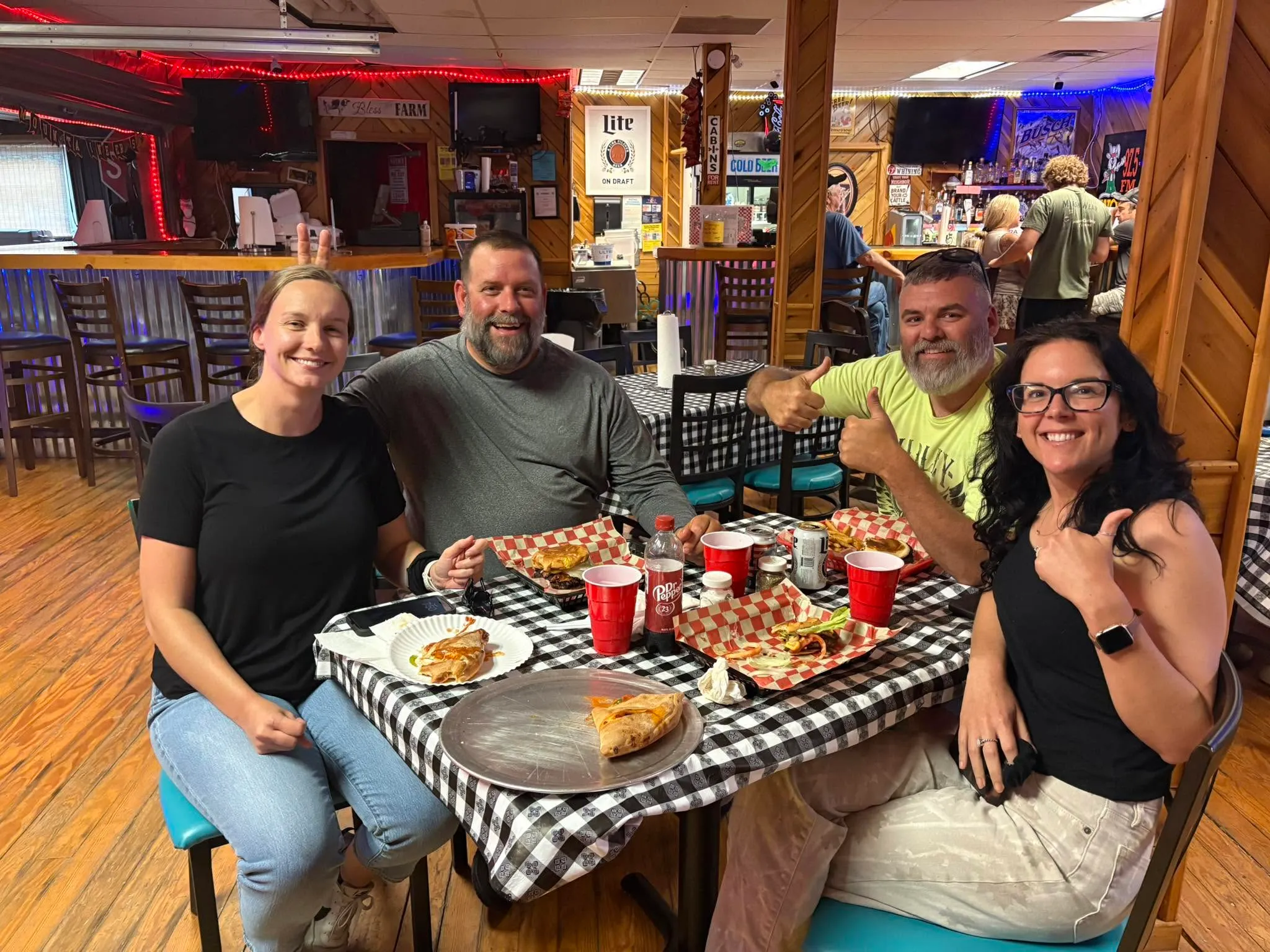 Happy friends enjoying pizza and drinks at The Farm Bar & Grill Charleston WV
