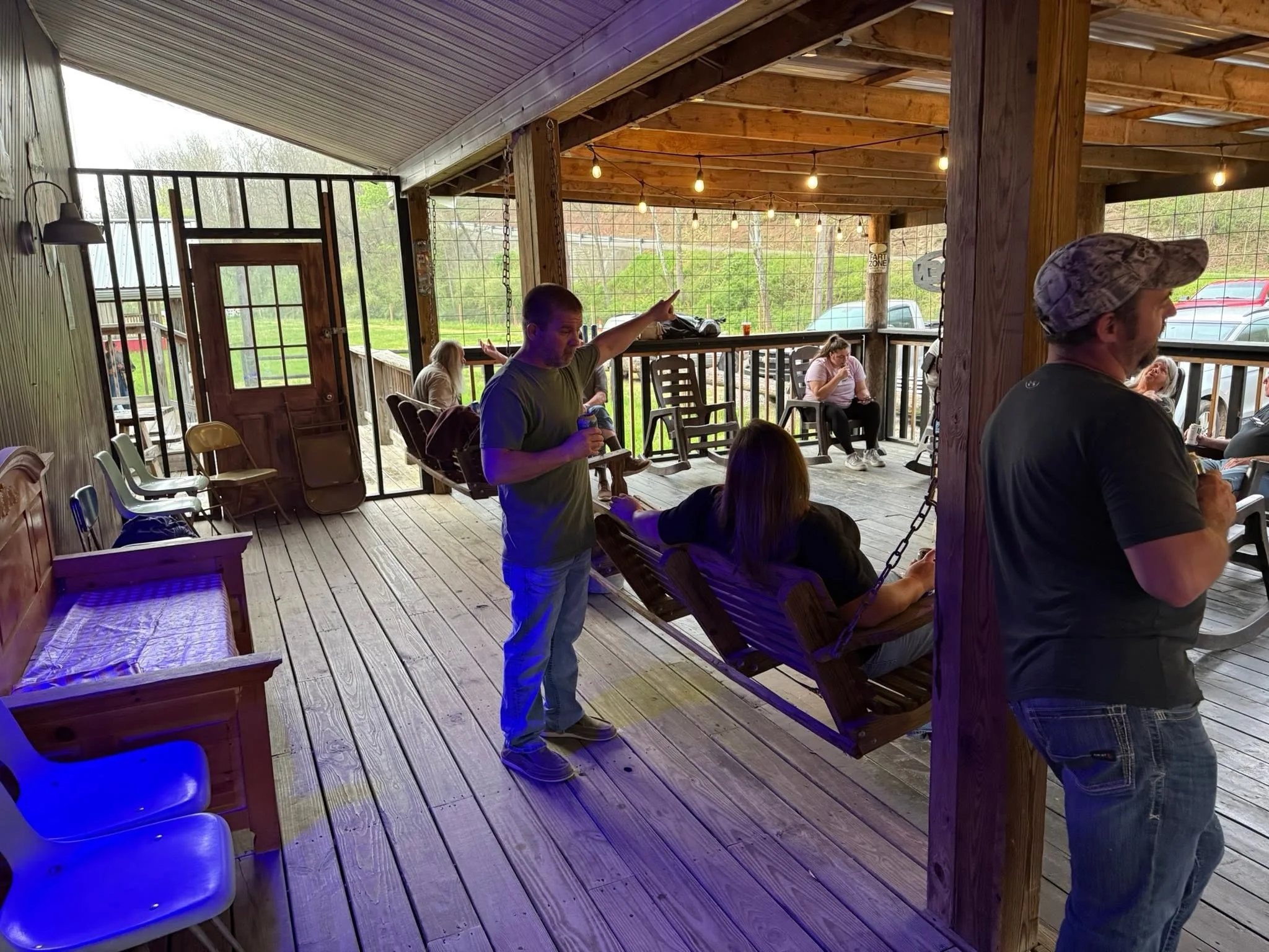Friends hanging out on The Farm porch swing and deck
