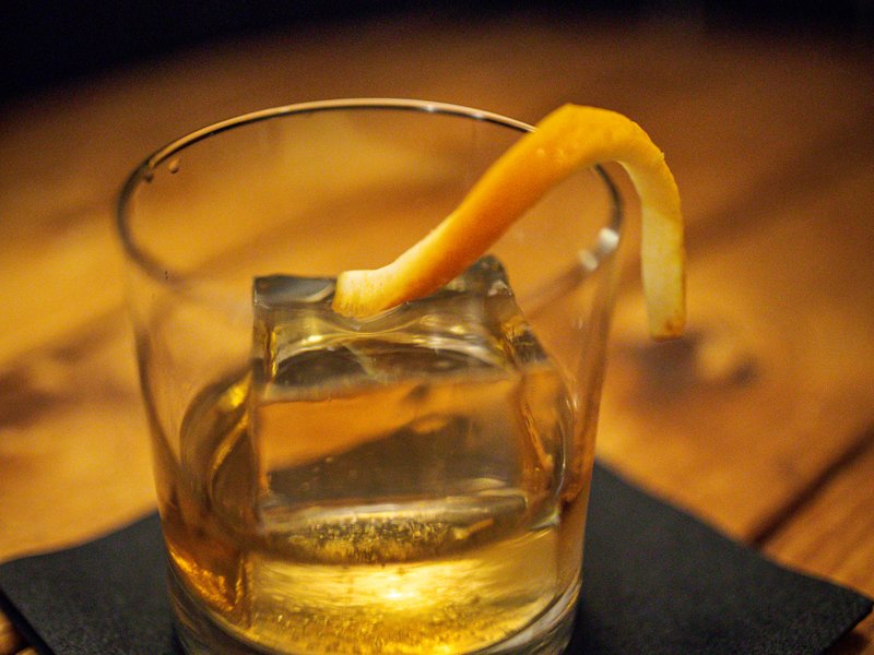 Premium whiskey with orange garnish